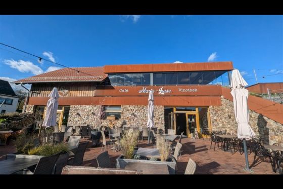 Gebäudefassade mit Schriftzug Café Marie-Luise Vinothek und bestuhlter Terrasse im Vordergrund