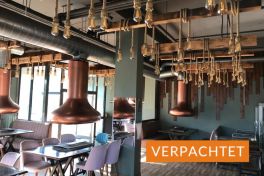 Innenansicht Restaurant mit Holztäfelung, Tischen und Deckenbeleuchtung