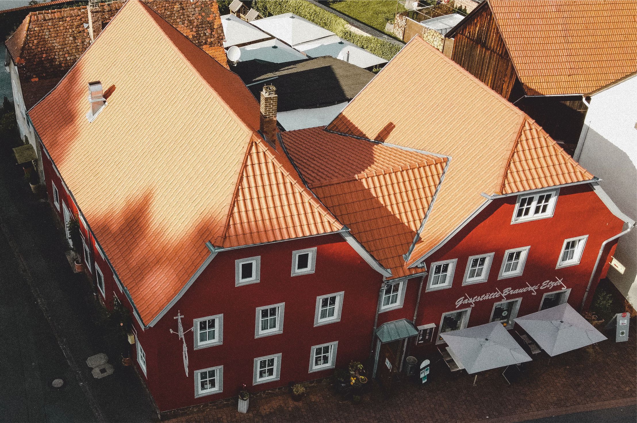 Luftaufnahme des Anwesens mit Innenhof, Biergarten und Nebengebäuden