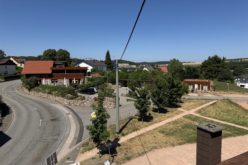 Außenansicht des Café Marie-Luise mit Vinothek in Nohfelden-Bosen, davor die Terrasse mit Sonnenschirmen