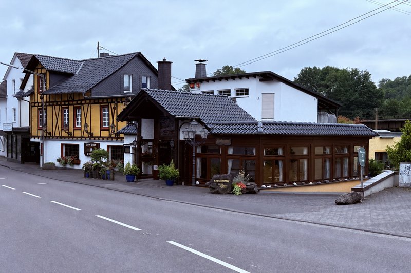 Gasthaus Zur Post in Windeck-Rosbach von der Rathausstraße aus: gelbes Fachwerkhaus mit angebautem Restaurantflügel